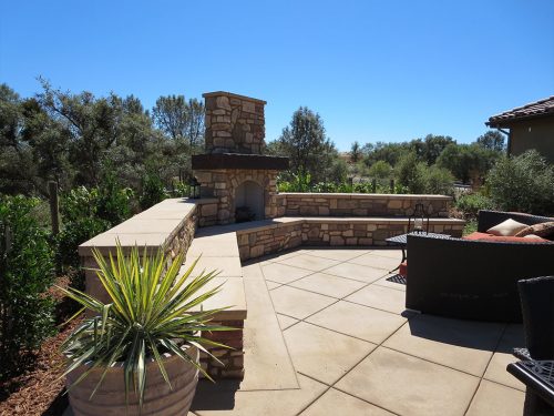 custom masonry seating area surrounding a firepit and picnic table